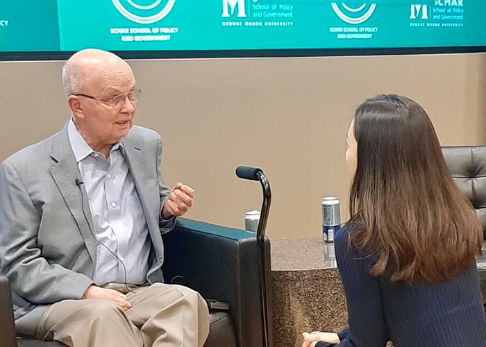 A woman interviews a man sitting in a chair.