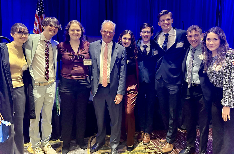 Senator Tim Kaine standing in the middle of a group of Schar School Democracy Lab students