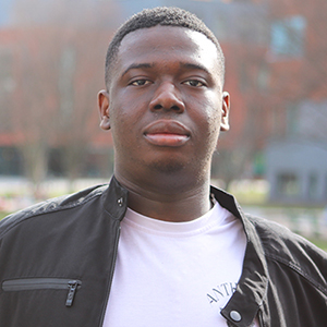 Chesney Noye standing outside on the Fairfax Campus while wearing a black jacket and white shirt.