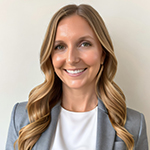 Shea M. Holman Kilian stands wearing a gray blazer and white shirt while smiling