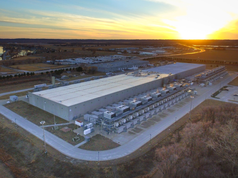 An aerial view of a data center with the sun rising in the background