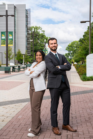 Maria Cuesta and Colin McAulay pose back-to-back on Wilkin Plaza