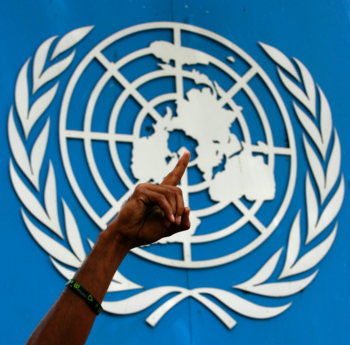 The logo of the UN has a hand with a finger in the air in front of it.